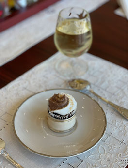 small desert on plate with wine glass and place setting